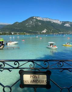 a sign that reads point be amour on a railing with boats in the water at LE LOFT SOMMEILLER 19*** Près du Lac in Annecy