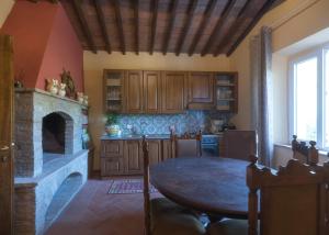 uma cozinha com uma mesa e uma lareira em La Casa Rossa em Coiano