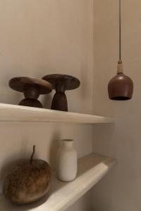 una mensola con tre ciotole di legno e un vaso. di Narrativ Lofts - Lira - Mid Century Cozy Retreat a Campeche