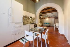 a kitchen with a glass table and white cabinets at Classic Loft by Mmega in Florence