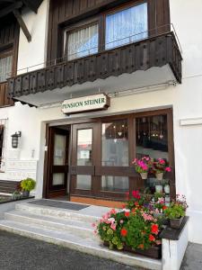 un edificio de ciencia de fusión con flores delante en Pension Steiner, Matrei am Brenner 18b, 6143 Matrei am Brenner, en Mühlbachl