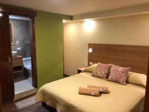 een slaapkamer met een bed met twee handdoeken erop bij Hostal Terra 4 - EL LABRADOR in Quito