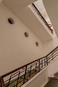 un escalier avec des murs blancs et une rampe noire dans l'établissement Narrativ Lofts - Lira - Mid Century Cozy Retreat, à Campeche