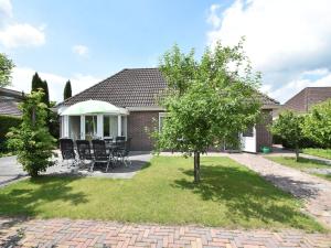 Cette maison dispose d'une terrasse avec des chaises et un arbre. dans l'établissement Boutique Holiday Home in Zeewolde with Swimming Pool, à Zeewolde