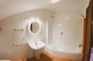 a white bathroom with a sink and a bath tub at Ca l'Andreu in Saldés