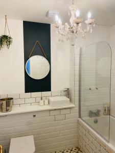 a bathroom with a tub and a sink and a mirror at Stunning quirky home in Amble in Amble