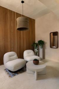 two chairs and a table in a living room at Narrativ Lofts - Lira - Mid Century Cozy Retreat in Campeche