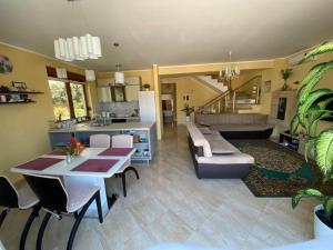 a living room with a dining table and a kitchen at Villa Eseniya in Tivat