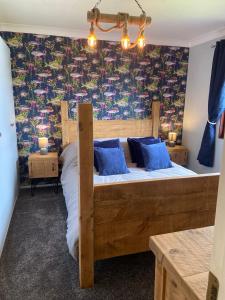 a bedroom with a wooden bed with blue pillows at Stunning quirky home in Amble in Amble