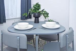 einem blauen Tisch mit zwei Tassen, Tellern und Stühlen in der Unterkunft GREEN DOOR in Etruria
