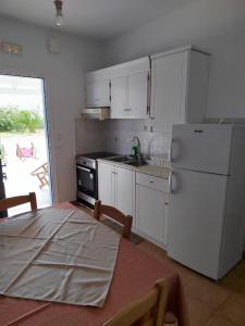 a kitchen with a table and a white refrigerator at Andreana's House in Antiparos