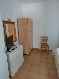 a bedroom with a dresser with a tv and a mirror at Andreana's House in Antiparos