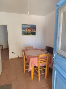 a dining room with a table and chairs and a painting at Andreana's House in Antiparos