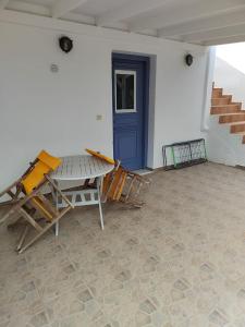 a patio with a blue door and a table and chairs at Andreana's House in Antiparos +2 photos