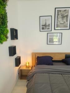ein Schlafzimmer mit einem Bett und einige Bilder an der Wand in der Unterkunft La maison des castors -1 flat and 1 studio in Bièvres