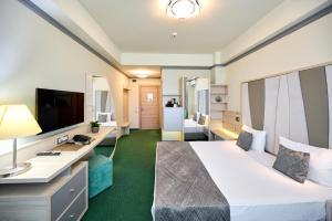 Cette chambre comprend un lit et un bureau. dans l'établissement Hotel Malibu, à Mamaia