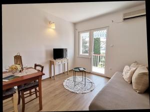 a living room with a couch and a table at Seaside Apartments Pinezic in Malinska