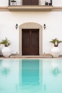 a house with a swimming pool in front of a door at Villa Platani Luxury Suite in Cianciana