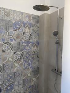 a bathroom with a shower with blue and white tiles at Luxury studio on the beach in Ios Chora