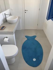 a bathroom with a blue rug on the floor at Luxury studio on the beach in Ios Chora