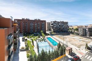 an apartment complex with a swimming pool and buildings at Apartamento Fénix in Granada