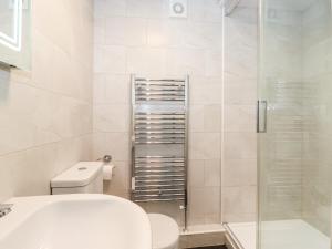 a bathroom with a toilet and a glass shower at Holly Cottage in Ambleside +30 photos