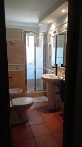 y baño con 2 aseos, lavamanos y ducha. en El amanecer, en El Puerto de Santa María