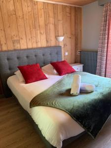 a bedroom with a large bed with red pillows at Hotel Le Concorde in Morzine