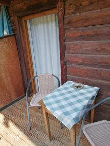 einen Tisch und einen Stuhl auf der Veranda einer Hütte in der Unterkunft Gasthaus - Pension - Café Dörfl in Kiefersfelden
