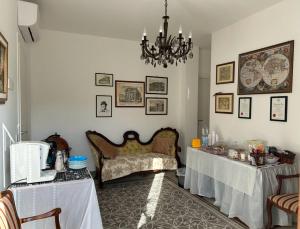 a room with two tables and a couch and a chandelier at Villa Elena - Terra dei Miti - Agropoli, Ogliastro Cilento in Ogliastro Cilento