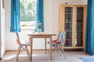 a table with three chairs and a table with flowers on it at Korzenny Domek in Korzenna