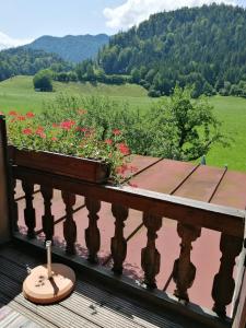 a room with a balcony with a table and flowers at Gasthaus - Pension - Café Dörfl in Kiefersfelden