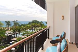a balcony with chairs and a view of the ocean at The Westin Desaru Coast Resort in Desaru