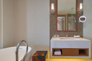 a bathroom with a sink and a tub and a mirror at The Westin Desaru Coast Resort in Desaru
