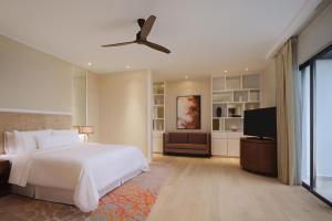 a bedroom with a bed and a flat screen tv at The Westin Desaru Coast Resort in Desaru