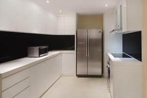 a stainless steel refrigerator in a white kitchen at The Westin Desaru Coast Resort in Desaru