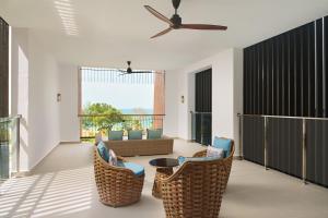 a living room with chairs and a couch and a ceiling fan at The Westin Desaru Coast Resort in Desaru