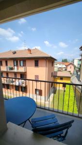 einen Balkon mit einem blauen Tisch und Stühlen sowie ein Gebäude in der Unterkunft Comfort Accommodation Room in Bergamo