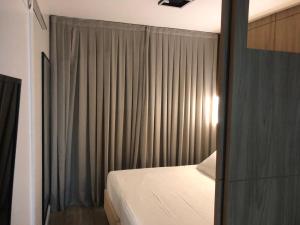 een slaapkamer met een bed en een raam met gordijnen bij Apart-hotel Central com Spa in Balneário Camboriú