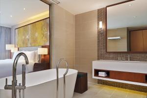 a bathroom with a tub and a bed and a mirror at The Westin Desaru Coast Resort in Desaru