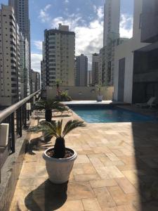 een balkon met een zwembad en een aantal gebouwen bij Apart-hotel Central com Spa in Balneário Camboriú