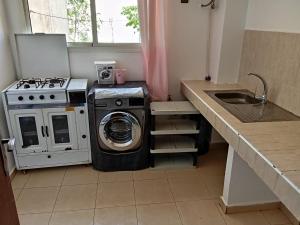 - une cuisine avec un lave-linge à côté d'un évier dans l'établissement Appartement Ifrane, à Ifrane