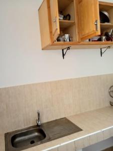 - un comptoir de cuisine avec évier et placards en bois dans l'établissement Appartement Ifrane, à Ifrane