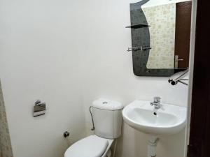 La salle de bains blanche est pourvue de toilettes et d'un lavabo. dans l'établissement Appartement Ifrane, à Ifrane