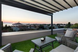 a patio with a table and chairs on a balcony at Boutique Residence Arion in Rovinj