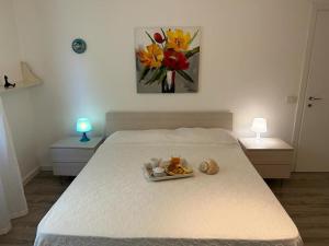 a bed with a tray of food and flowers on it at Appartamento in villetta a 2 passi dal mare e dal centro in Pesaro