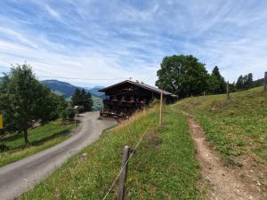 a house on a hill next to a road at Hinterfoisching - Chalet nahe Kitzbühel in Westendorf