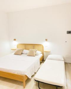 2 camas en una habitación con paredes blancas en CASA SACURI, en Rudalza