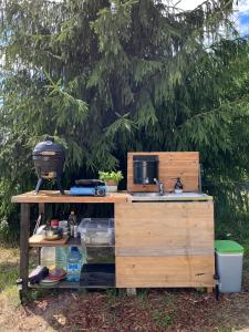 a wooden counter with a sink in front of a tree at Restu Forrest Glamp in Otepää