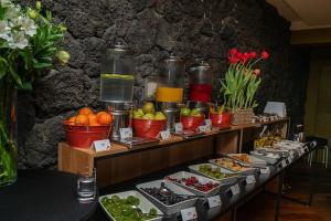 ein Buffet mit Speisen auf einem Tisch mit Obst und Gemüse in der Unterkunft Hotel Cumbres Puerto Varas in Puerto Varas